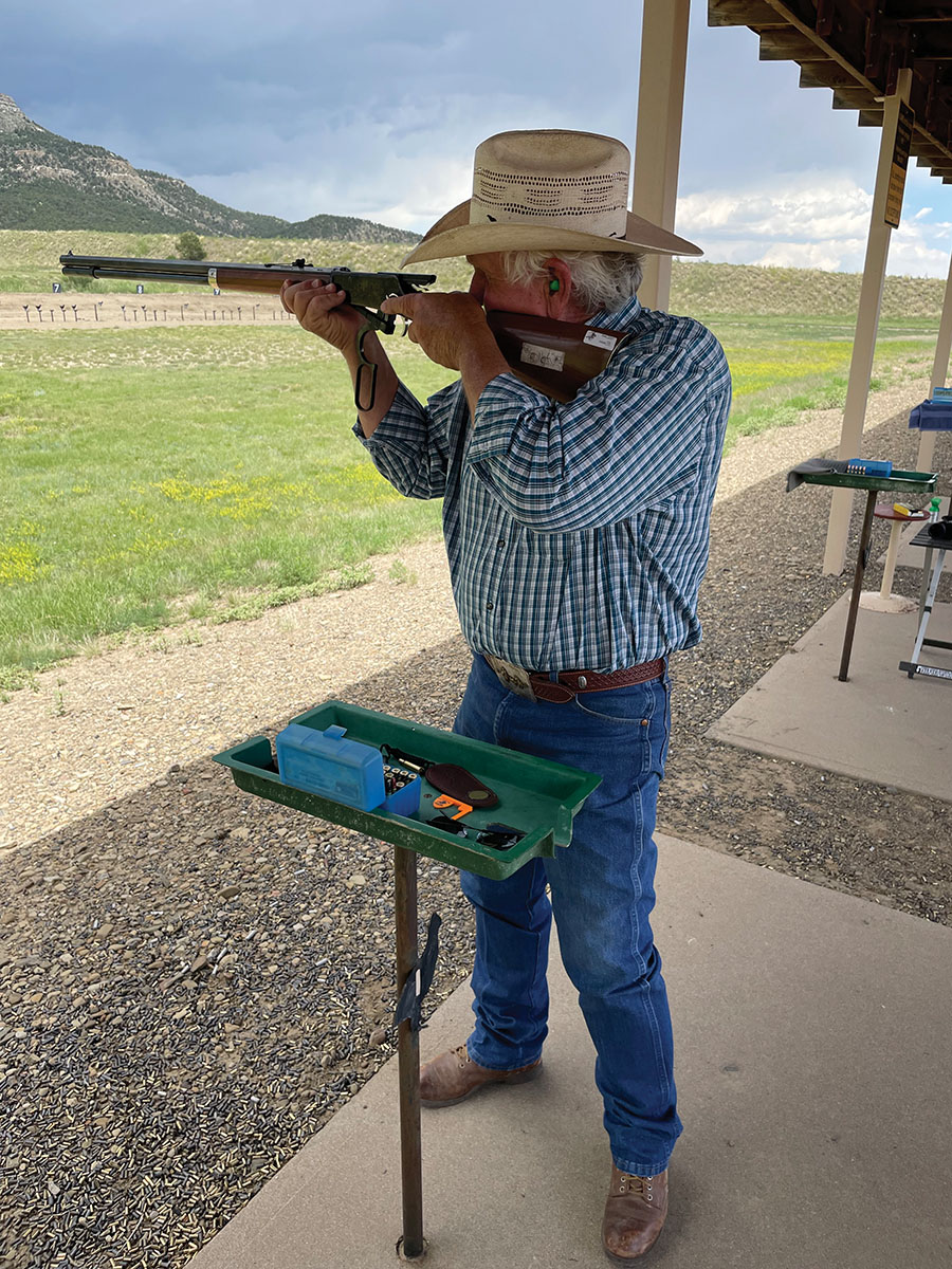 Bob Jenkins, a New Mexico cowboy, checks his sights before a relay. The stepped slider rear sights as found on most factory guns can work quite well in this game with a little experimentation. The white tape on the stock has a reminder of which step to use for each different distance.